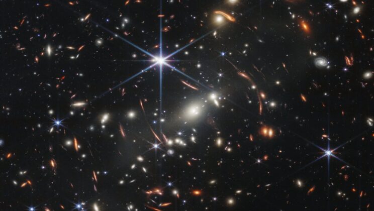 This strange curved galaxy sits almost exactly where a cluster’s gravity should create a cosmic arc